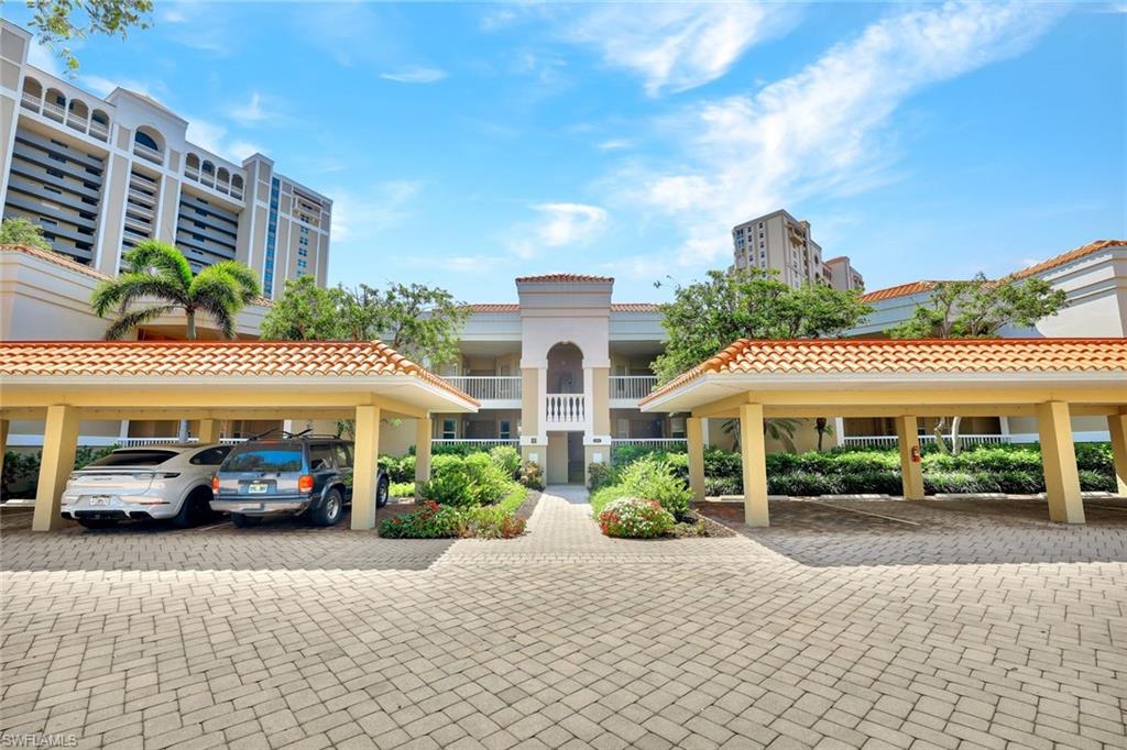 6549 Marissa Loop, Unit 21 Naples, FL 34108 - Photo 20 of 20 a front view of a building with cars parked