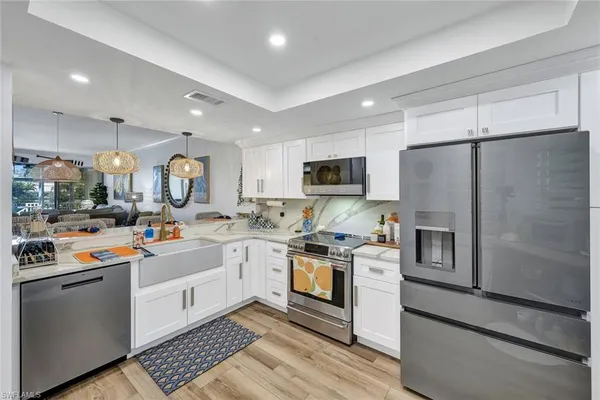 a kitchen with stainless steel appliances a stove refrigerator sink and microwave