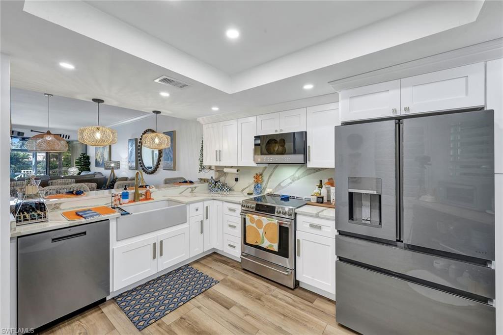 6549 Marissa Loop, Unit 21 Naples, FL 34108 - Photo 5 of 20 a kitchen with stainless steel appliances a stove refrigerator sink and microwave
