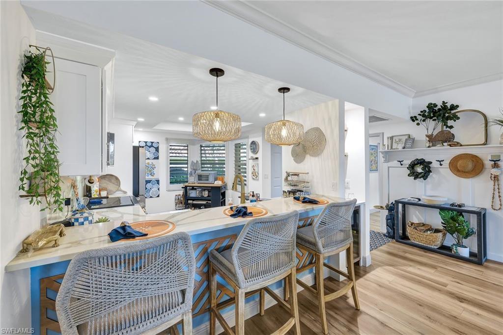 6549 Marissa Loop, Unit 21 Naples, FL 34108 - Photo 7 of 20 a very nice looking dining room with a large dining table and chairs with wooden floor