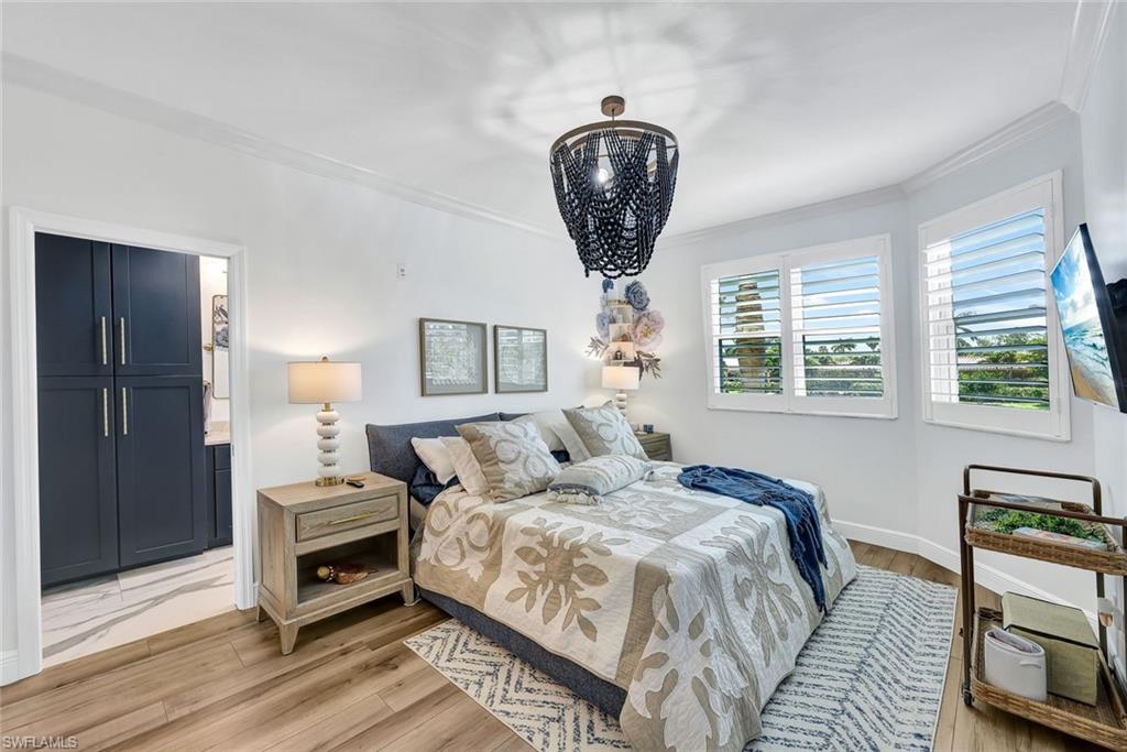 6549 Marissa Loop, Unit 21 Naples, FL 34108 - Photo 9 of 20 a bedroom with bed and a chandelier
