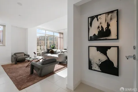 a living room with furniture and a painting on the wall