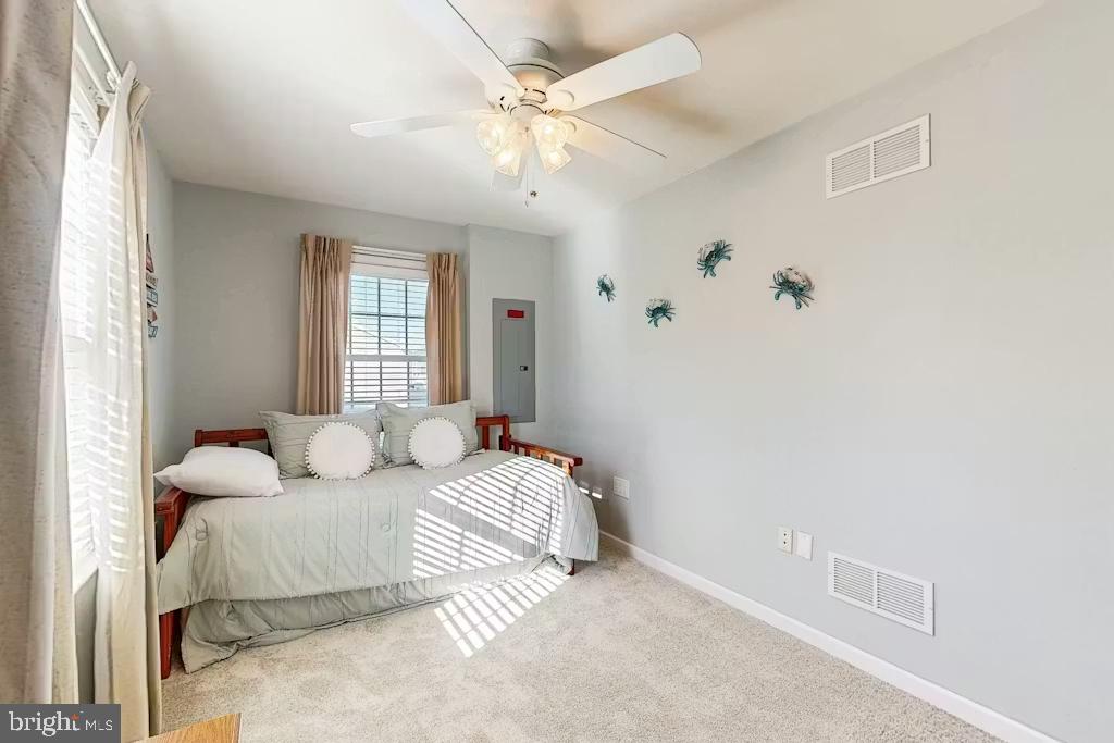 37022 Blue Teal Road Selbyville, DE 19975 - Photo 16 of 20 a bedroom with a white bed and a chandelier