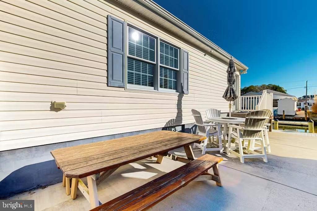 37022 Blue Teal Road Selbyville, DE 19975 - Photo 20 of 20 a roof deck with table and chairs with wooden floor and fence