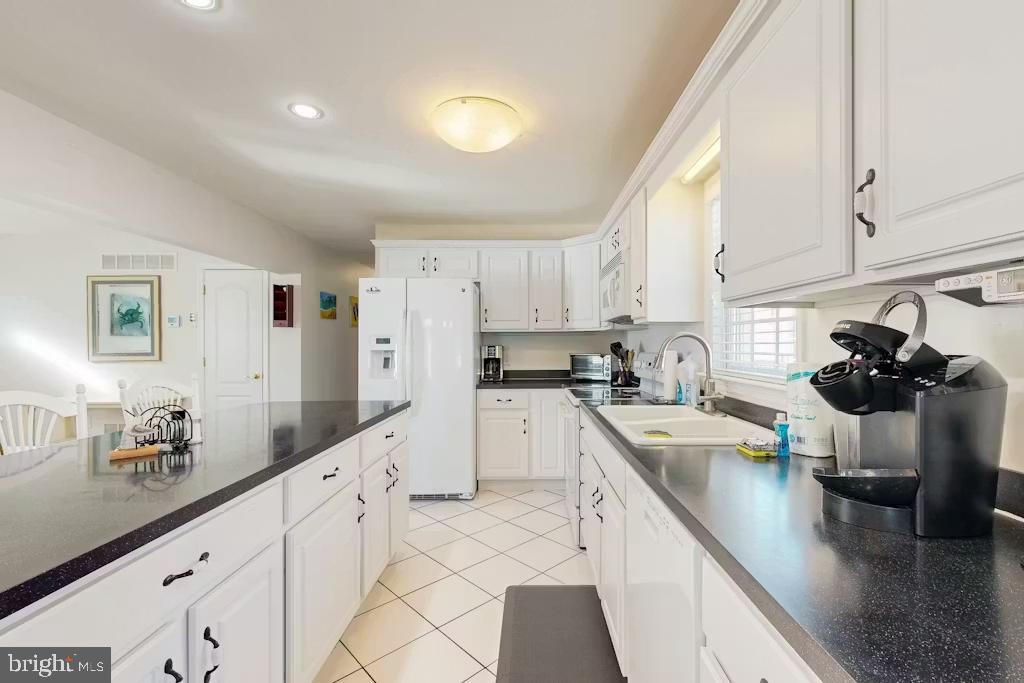 37022 Blue Teal Road Selbyville, DE 19975 - Photo 5 of 20 a kitchen with granite countertop a sink a stove and cabinets