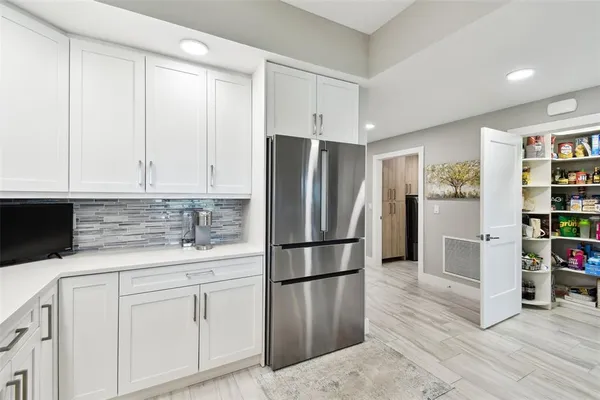 a kitchen with stainless steel appliances white cabinets and a refrigerator