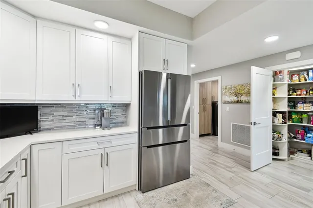 a kitchen with stainless steel appliances white cabinets and a refrigerator