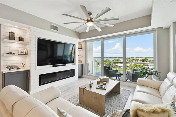 a living room with furniture a flat screen tv and a large window