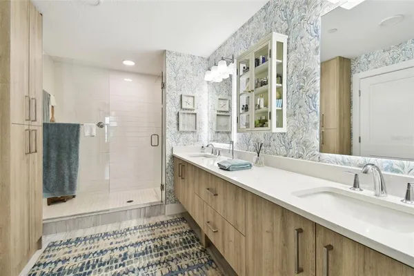 a bathroom with a double vanity sink mirror and shower