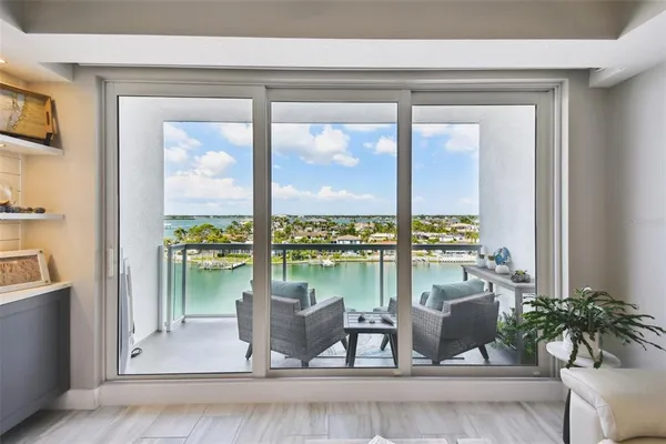 a living room with furniture and floor to ceiling windows