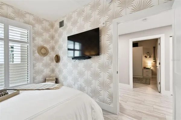 a bedroom with a bed and a flat screen tv