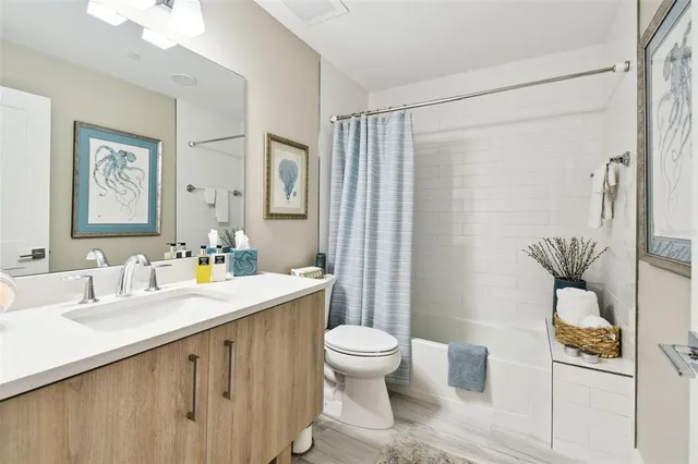 a bathroom with a granite countertop sink toilet and shower