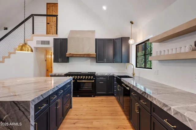 a kitchen with stainless steel appliances granite countertop wooden cabinets a stove top oven a sink and dishwasher