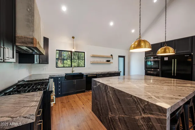 a kitchen with stainless steel appliances granite countertop a stove a sink and a microwave