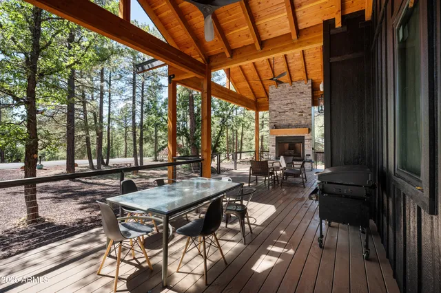 a view of a patio with table and chairs and couches with wooden floor and fence
