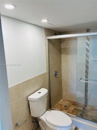 a bathroom with a granite countertop toilet and a sink