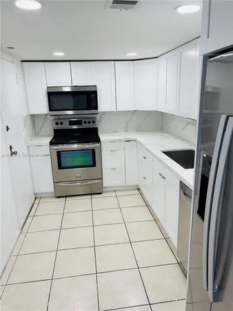 a kitchen with a stove top oven and cabinets