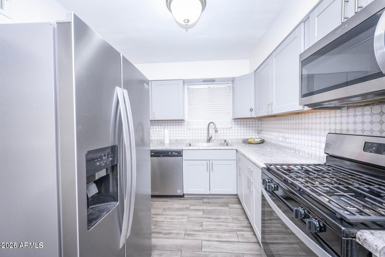 2101 West Glenn Drive Phoenix, AZ 85021 - Photo 15 of 48 a kitchen with stainless steel appliances granite countertop a refrigerator and a stove top oven