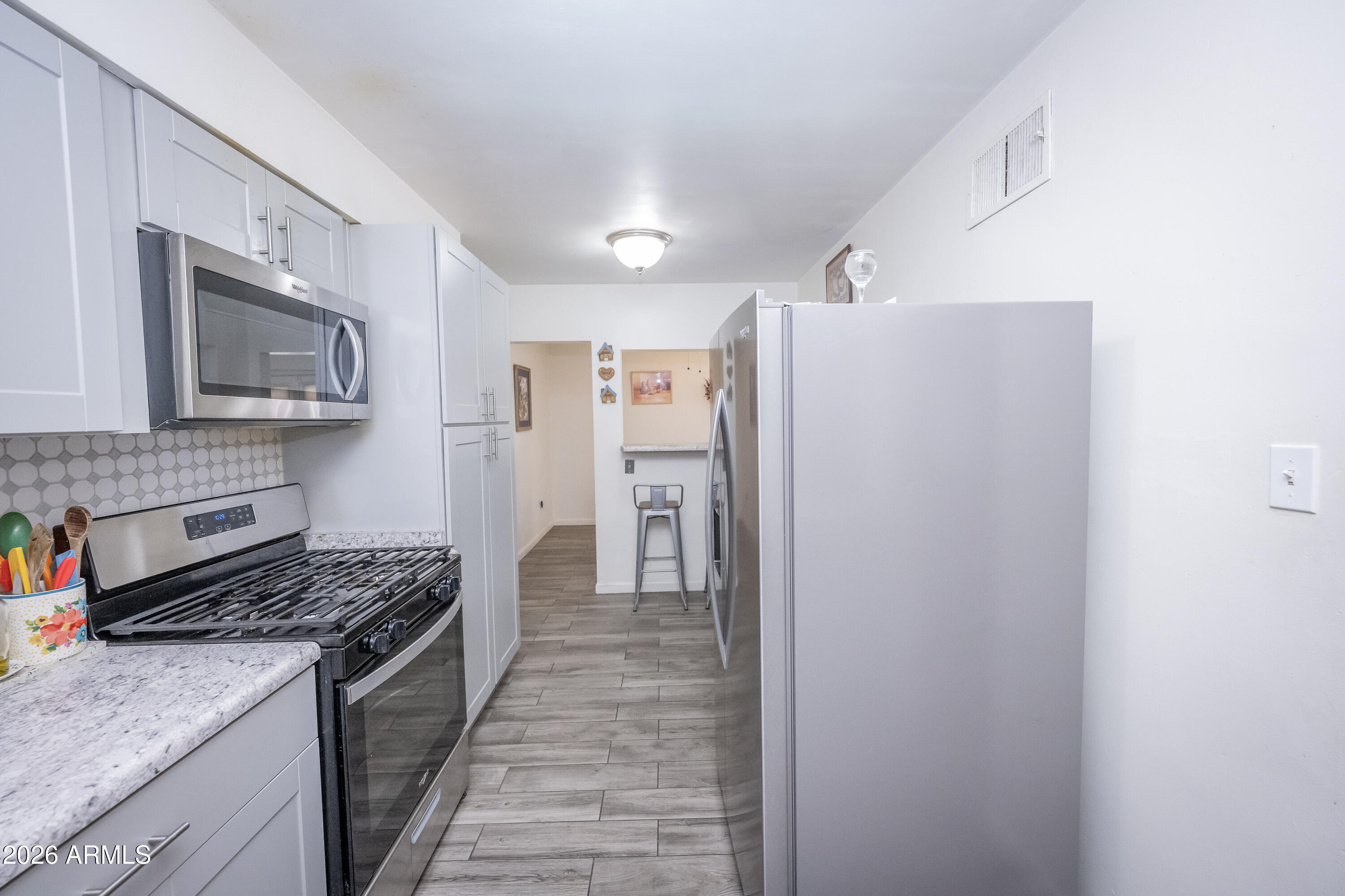 2101 West Glenn Drive Phoenix, AZ 85021 - Photo 17 of 48 a kitchen with stainless steel appliances granite countertop a refrigerator and a stove top oven