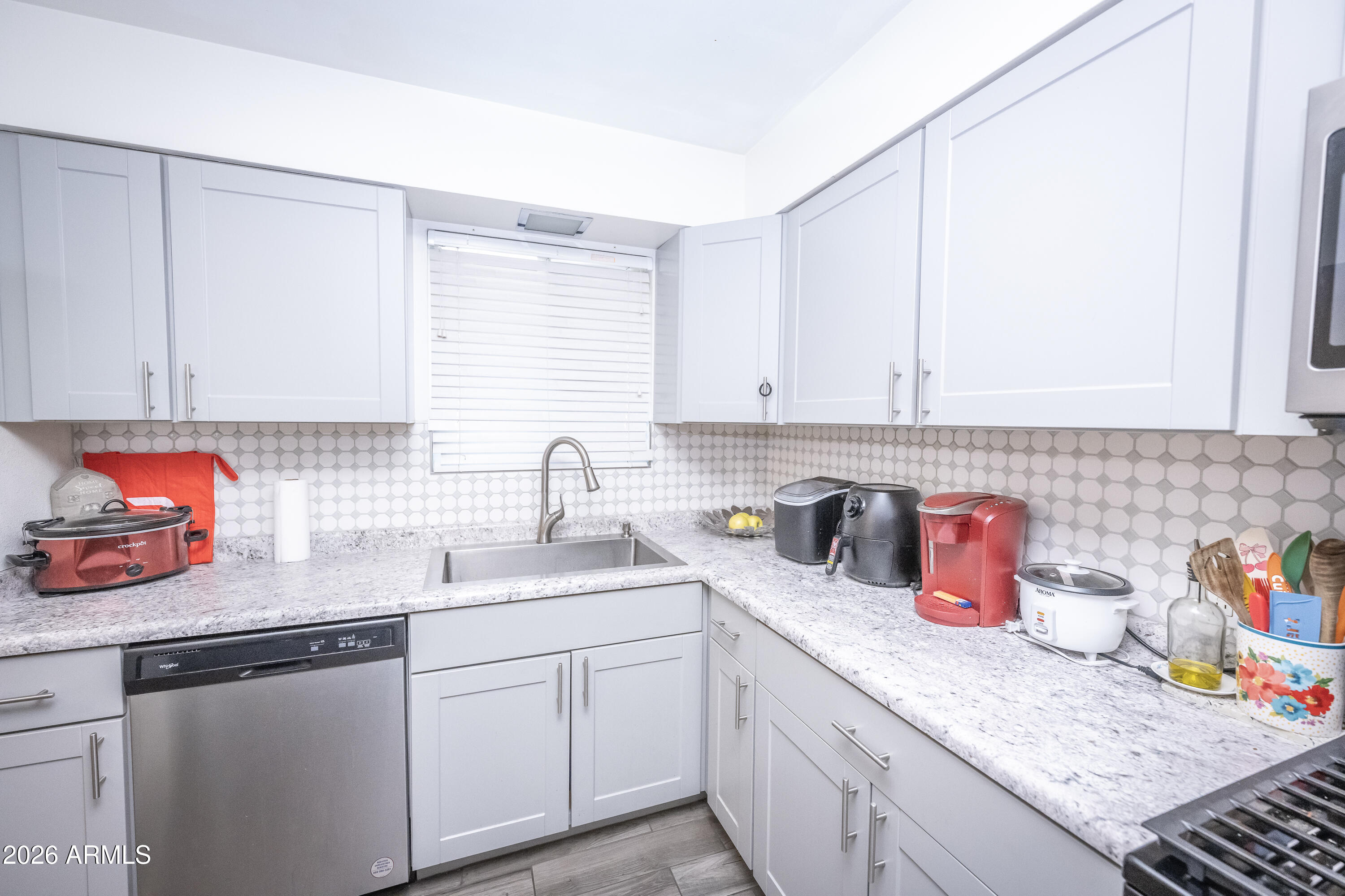 2101 West Glenn Drive Phoenix, AZ 85021 - Photo 18 of 48 a kitchen with stainless steel appliances granite countertop a sink dishwasher and cabinets with wooden floor