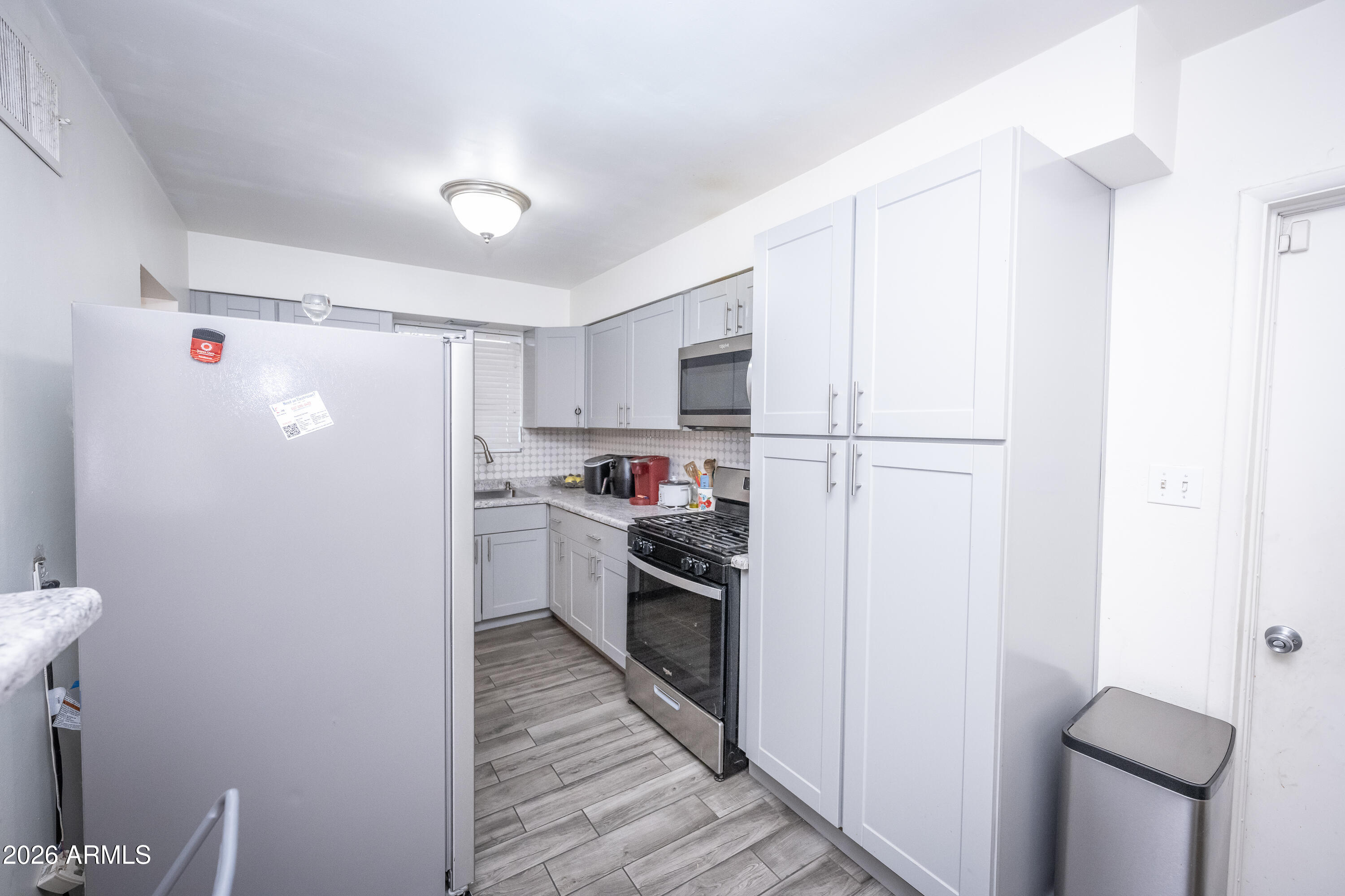 2101 West Glenn Drive Phoenix, AZ 85021 - Photo 20 of 48 a kitchen with a refrigerator sink and wooden cabinets