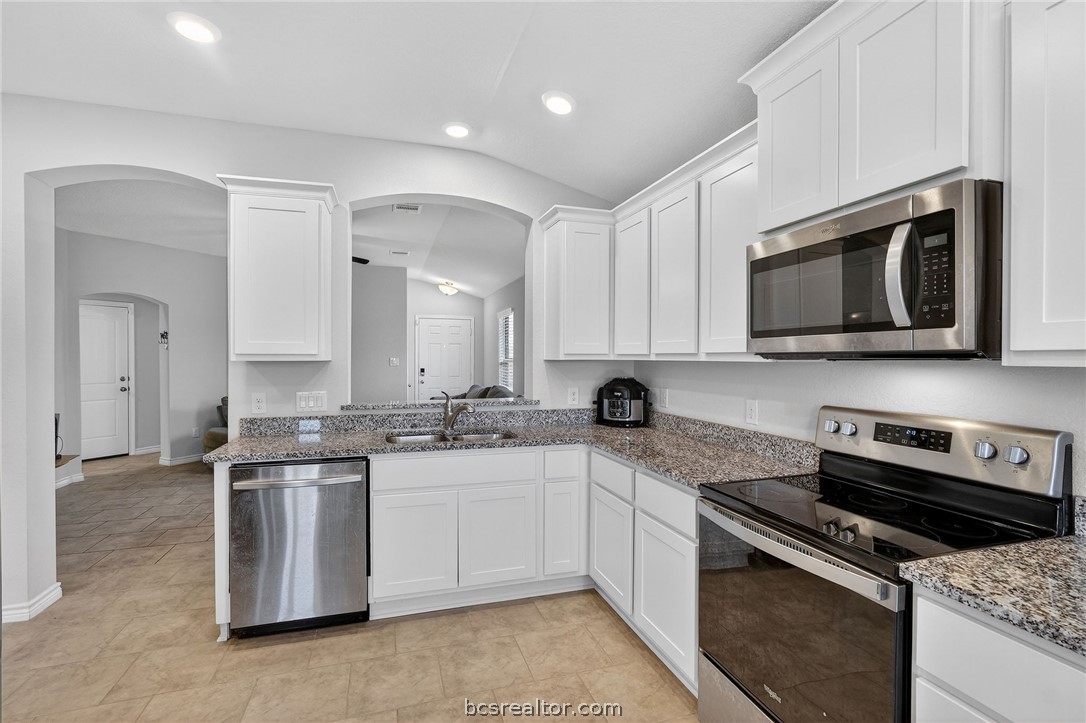 5235 Montague Loop Bryan, TX 77807 - Photo 6 of 25 a kitchen with stainless steel appliances granite countertop a stove top oven a sink and dishwasher