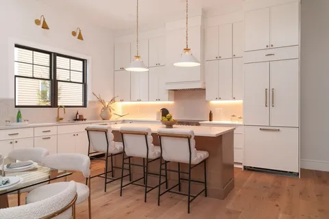 a kitchen with a sink white cabinets and white appliances