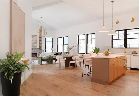 a very nice looking living room with a large window a couch and potted plant