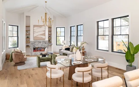 a living room with fireplace furniture and a large window