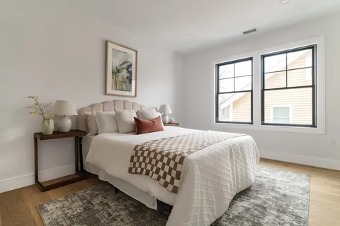a bed sitting in a bedroom next to a window