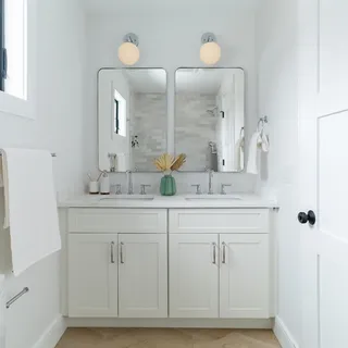 a bathroom with double vanity sinks and a mirror