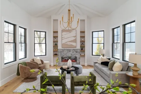 a living room with fireplace furniture and a large window