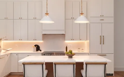 a kitchen with a sink a stove and white cabinets