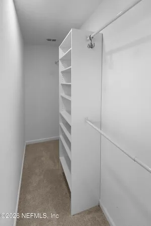 a view of walk in closet with empty racks