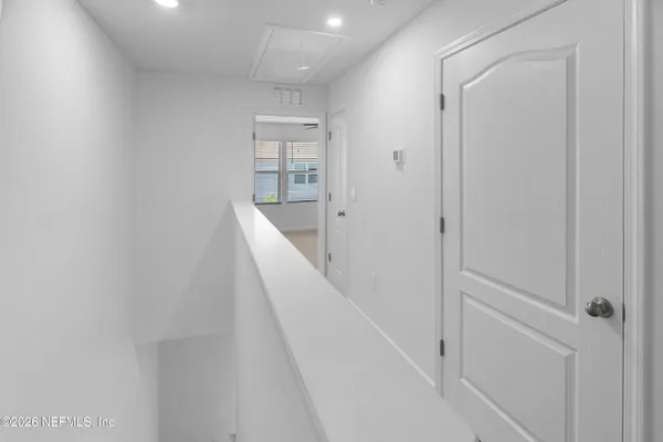 a view of a hallway with wooden floor and entryway