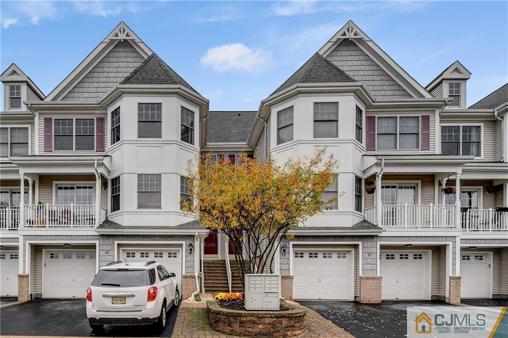 a front view of a residential apartment building with a yard and garage