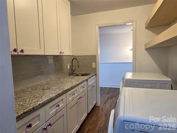 a kitchen with granite countertop a sink and a stove