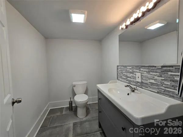 a bathroom with a sink mirror and toilet