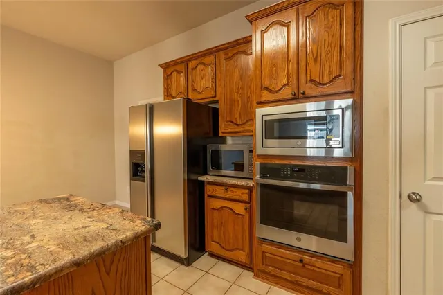 a kitchen with granite countertop stainless steel appliances and wooden cabinets