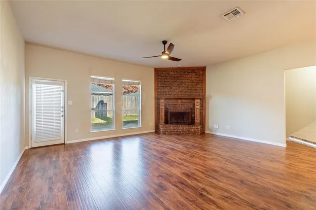 a view of empty room with wooden floor and fireplace