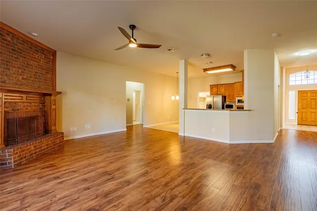 a view of a kitchen with wooden floor and a fireplace