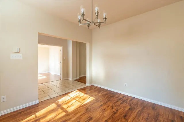 a view of a room with a chandelier fan and wooden floor