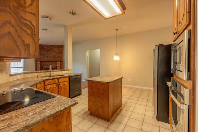 a kitchen with stainless steel appliances granite countertop a sink and a stove