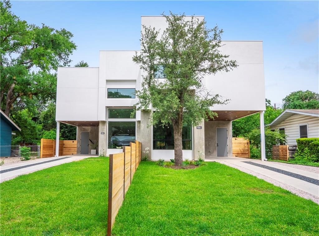 a view of a house with backyard and a tree