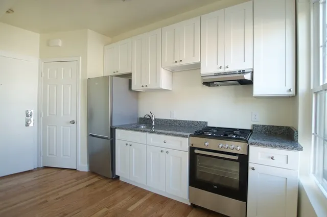 a kitchen with stainless steel appliances granite countertop a stove a refrigerator and a cabinets