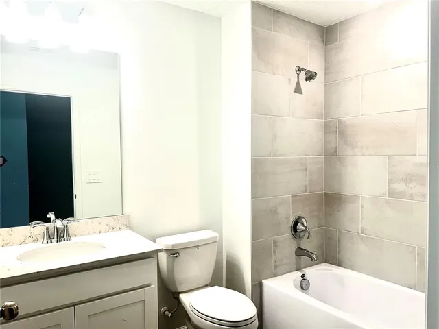 a white toilet and tub sitting next to a bathroom sink