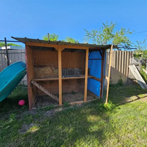 a view of backyard with wooden fence and a tub