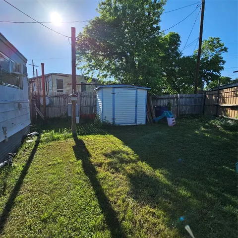 a view of a backyard with a small cabin and wooden fence