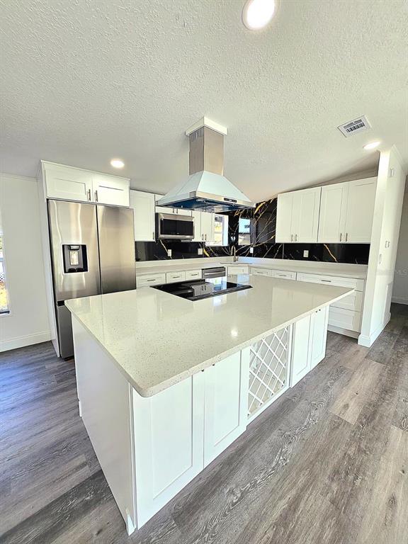 4928 Rollinglen Loop East Lakeland, FL 33810 - Photo 30 of 44 a kitchen with stainless steel appliances a white stove top oven a sink dishwasher and a refrigerator with wooden floor