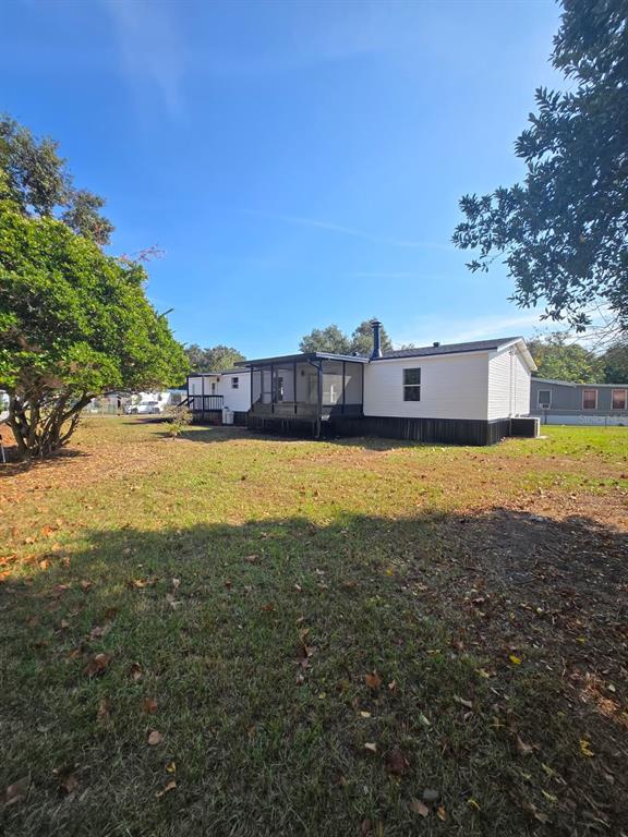 4928 Rollinglen Loop East Lakeland, FL 33810 - Photo 9 of 44 a view of a large pool with lawn chairs and large trees